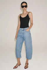 Jeans capri balloon leg de tiro medio en color celeste, con trabillas para cinto, bolsillos delanteros y traseros, y cierre frontal con botón y cremallera.