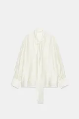 Camisa de tejido satinado con mezcla de lyocell, cuello redondo con escote en pico y detalle de lazada frontal. Presenta mangas largas con puños anchos y bajo recto.