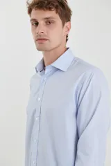 Camisa celeste con microestampado blanco, de corte clásico, manga larga y cuello italiano.