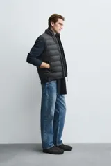 Chaleco acolchado de hombre color negro, con diseño puffer, cuello alto y cierre frontal con cremallera.