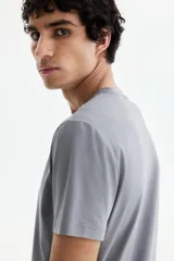 Remera de punto liviano color gris, con cuello redondo y diseño slim fit. Confeccionada con fibra sintética COOLMAX®.