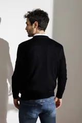 Sweater azul marino de lana merino, con cuello redondo y mangas largas. Tejido de punto liso. Corte clásico.