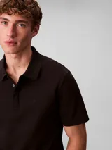Chomba de manga corta Calvin Klein confeccionada en algodón interlock, con cuello clásico y cierre frontal de dos botones.