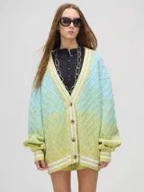 Cardigan de punto con diseño degradé en tonos tierra, patrón de rombos en relieve, cuello en V con cartera de botones y puños con rayas blancas y marrones.