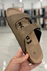 Sandalia marrón con diseño de dos tiras ajustables con hebillas metálicas y plantilla anatómica.