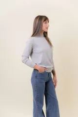 Buzo de tejido fino color amarillo claro, con cuello semi alto, manga larga y calce regular.