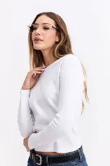 Remera de manga larga con cuello redondo y ajuste al cuerpo, confeccionada en tejido de algodón con textura acanalada.