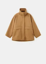 Chaqueta oversize color tostado con cuello embudo, manga larga, bolsillos laterales y bolsillos de parche con solapa. Cuenta con cierre delantero de cremallera y botones ocultos bajo tapeta, y forro interior.