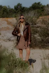 Top tejido al crochet color crudo, con diseño de flor en el frente, corte triangular y tiras finas para atar en el cuello y la espalda.