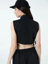 Top negro sin mangas con cuello camisero y cierre con botones.