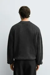 Polo de punto tejido en algodón con efecto lavado, de corte relajado, cuello solapa con cierre frontal de botones, manga larga y acabados en rib.