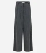 Pantalón de corte amplio tipo pantalona, confeccionado en tejido con patrón de rayas diplomáticas. Presenta cintura alta con trabillas para cinturón y cierre frontal tradicional.