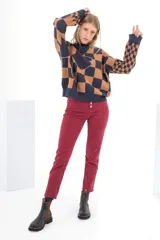 Pantalón de jean rojo, de tiro alto y corte skinny, con cierre frontal con botones a la vista.