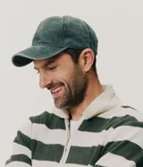 Gorra de seis paneles confeccionada en algodón con acabado desteñido, visera curva y regulador trasero.