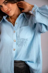 Camisa color beige de muselina con bordado en la parte delantera y mangas globo.