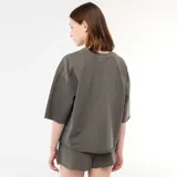 Remera oversize gris con efecto acid wash, cuello redondo, mangas cortas y estampa frontal con la palabra 'MALIBU' y estrellas en tonos blancos y rosados.