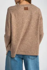 Sweater de tejido de punto color bordó, con cuello redondo, mangas largas y puños acanalados. Presenta un diseño de corte recto y textura suave.