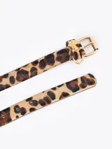 Cinturón negro de cuero vacuno con textura croco, hebilla dorada y aplique metálico de hongo dorado.