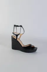 Sandalias de plataforma con taco corrido revestido en yute, confeccionadas en cuero color lila. Presentan diseño de puntera abierta y tiras largas para atar alrededor del tobillo.