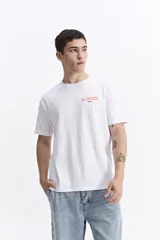 Remera de manga corta color verde menta, con escote redondo y fit regular. Presenta un estampado en la espalda con la frase "NO RULES! BREAK THE RULES" y un diseño abstracto en tonos azules y blancos.