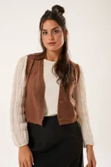 Chaleco color café de tejido sintético con escote en V y cierre frontal con botones forrados.