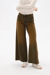 Pantalon de jean de corte ancho y tiro medio, con efecto de lavado desgastado en tonos marrones y verdosos. Cuenta con bolsillos laterales y traseros.