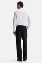 Camisa de corte entallado con cuello inglés, tapeta clásica y canesú en la espalda. Presenta mangas largas con puños ajustables mediante botones y bajo levemente redondeado. Confeccionada en tela con tratamiento de fácil planchado.