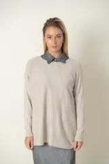 Buzo verde oliva de punto fino con detalle de líneas diagonales en el mismo material y cuello camisero blanco.