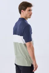 Remera polo de manga corta con diseño en bloques de color en tonos azul marino, blanco y verde militar, con bordado frontal y cierre de botones.