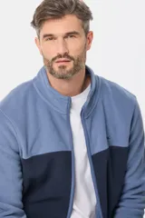 Campera de micro polar bondeado con diseño bicolor, combinando paneles en color terracota y azul marino. Presenta cuello alto, cierre frontal completo y bolsillos laterales con cierre.