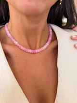 Collar corto de cuentas facetadas de acrílico en tonos rosados, con cierre de acero.