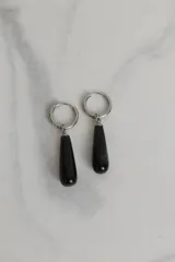 Aros tipo argolla de acero quirúrgico con dije colgante en forma de gota de piedra natural en tono marrón.