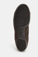 Zapatilla estilo blucher con diseño deportivo, confeccionada en una combinación de materiales textiles y gamuza en tono marrón, con detalle de contraste en color blanco en el talón y cierre mediante cordones.