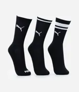 Kit de tres pares de medias deportivas Puma de caña larga, confeccionadas en algodón. Incluye un par blanco con rayas y logo azules, un par negro con rayas y logo blancos, y un par liso de color azul.