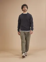 Pantalón cargo color verde oliva, de corte recto y tiro medio, con bolsillos laterales con fuelle y cierre de solapa.