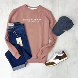 Buzo color rosa viejo de algodón con cuello redondo, puños y cintura acanalados. Estampa frontal con el texto "DUXON JEANS LOS ANGELES EST. 1982" en color blanco.