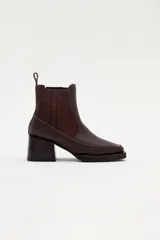 Bota tipo chelsea de cuero marrón con paneles laterales elásticos, taco cuadrado y punta cuadrada.
