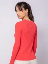 Cárdigan blanco de tejido de punto en rib irregular con broche metálico en la parte frontal.