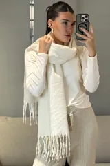 Bufanda de tejido de punto en color beige melange, con diseño rectangular y terminaciones con flecos en los extremos.