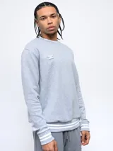 Buzo negro de corte clásico con cuello redondo, puños y ruedo acanalados con doble línea blanca. Logo de Umbro bordado en el pecho. Mangas con paneles laterales en gris. Confeccionado en algodón y poliéster.