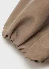 Mono largo color beige, con escote asimétrico de un solo hombro, manga corta abullonada, cintura elastizada y corte palazzo.