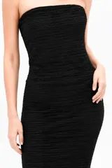 Vestido largo negro de poliéster, con diseño strapless y corte ajustado al cuerpo de textura acanalada.