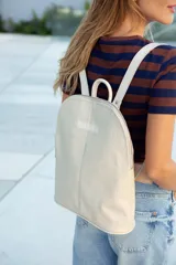 Mochila de cuero color natural con textura, cierre superior con doble cremallera, asa de mano y correas ajustables para los hombros.