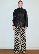 Pantalón largo de viscosa con estampado animal print tipo cebra en tonos beige y negro, de corte recto y holgado.