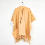 Ruana de tejido suave color mostaza, con diseño abierto y flecos en el ruedo.