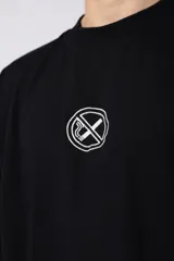 Remera de corte oversize confeccionada en algodón premium de alto gramaje. Presenta un diseño minimalista con un pequeño logo bordado en el centro del pecho y un parche estampado en la espalda. Posee cuello redondo y mangas cortas con caída relajada.