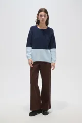 Sweater de tejido de punto con diseño color block, combinando azul marino en la parte superior y celeste en la inferior. Presenta cuello redondo a la base y mangas largas.