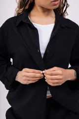 Camisa negra de lino, sin lycra, de mangas largas y corte clásico.