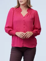 Blusa blanca de gasa con cuello a la base, escote en V y botones. Presenta punto smock en hombros y puños.