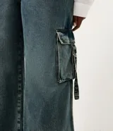 Pantalón de jean wide leg color azul, de tiro medio con bolsillos cargo laterales y diseño amplio en las piernas.